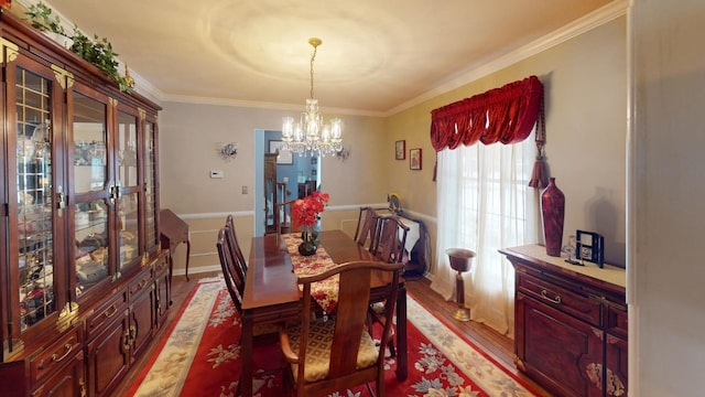 dining room with light hardwood / wood-style floors, ornamental molding, and an inviting chandelier