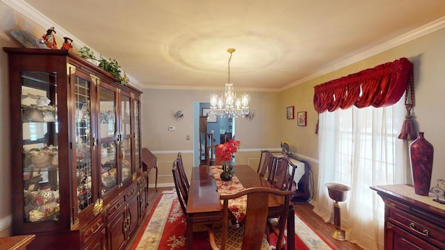 dining space with a chandelier, crown molding, and light hardwood / wood-style flooring