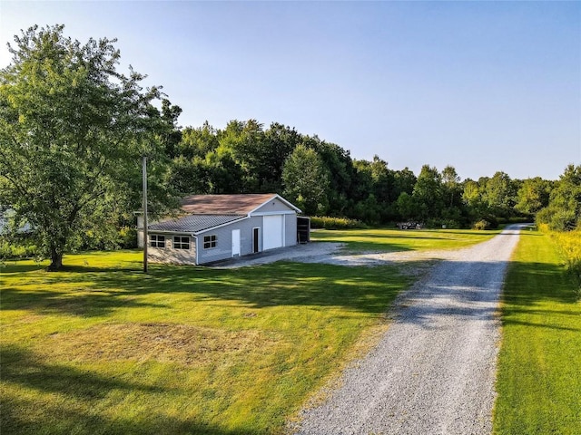 view of front of home featuring an outbuilding, a front yard, and a garage