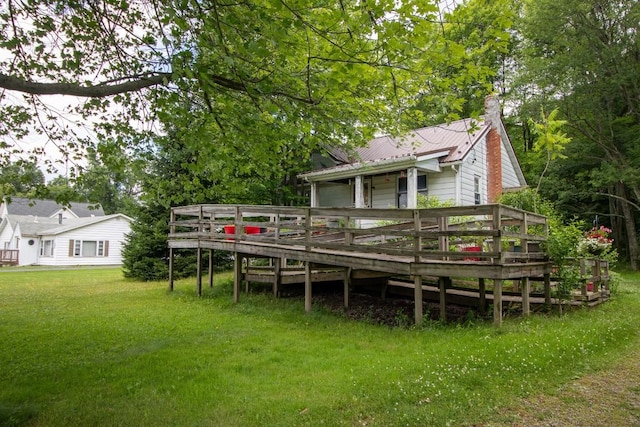 back of property with a deck and a lawn