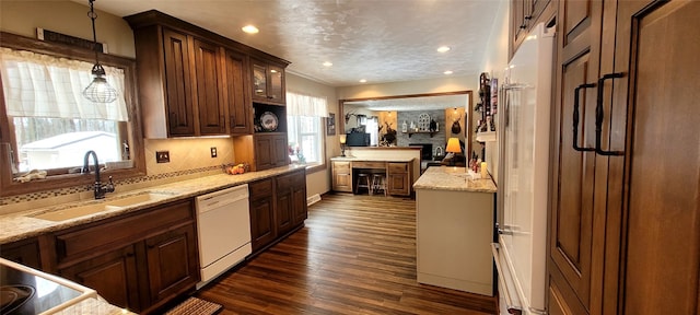 kitchen featuring hanging light fixtures, sink, a wealth of natural light, and white dishwasher