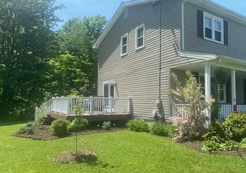 view of side of property featuring a wooden deck and a yard