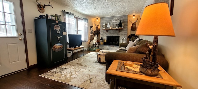 living room featuring a brick fireplace, dark hardwood / wood-style floors, and a textured ceiling