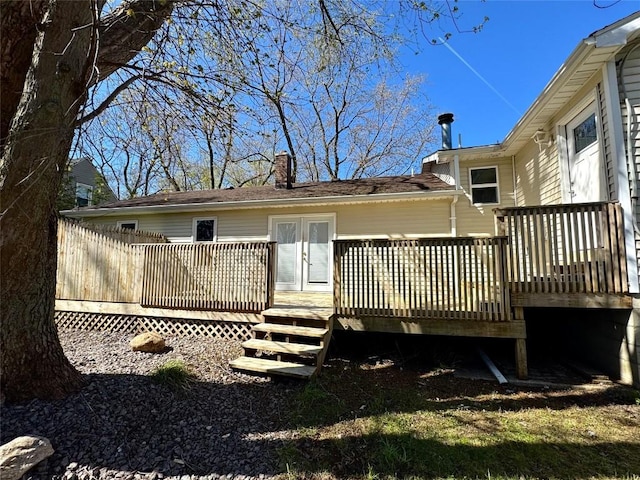 back of property featuring a wooden deck and a chimney