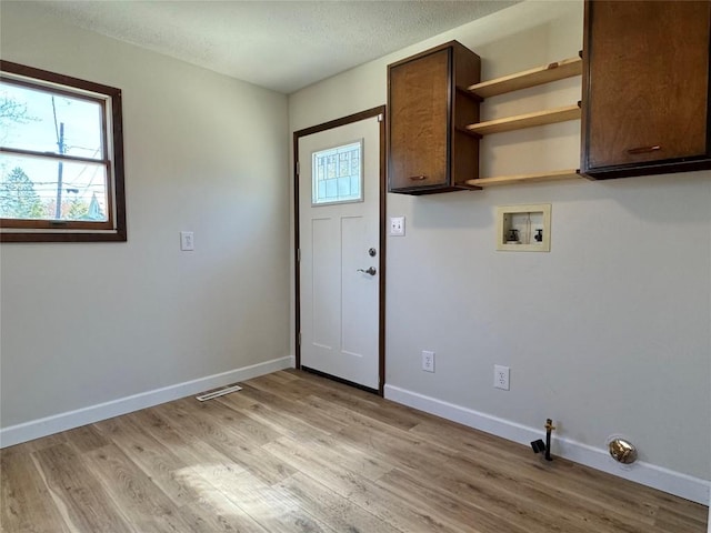 laundry room with washer hookup, light wood-style flooring, visible vents, baseboards, and cabinet space