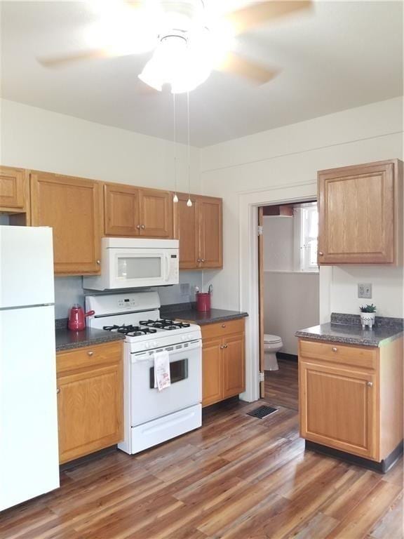 kitchen featuring ceiling fan, dark hardwood / wood-style floors, and white appliances