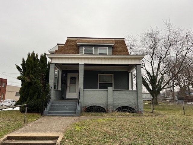 bungalow featuring covered porch and a front lawn