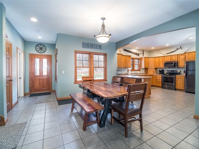dining room with recessed lighting, arched walkways, baseboards, and light tile patterned floors