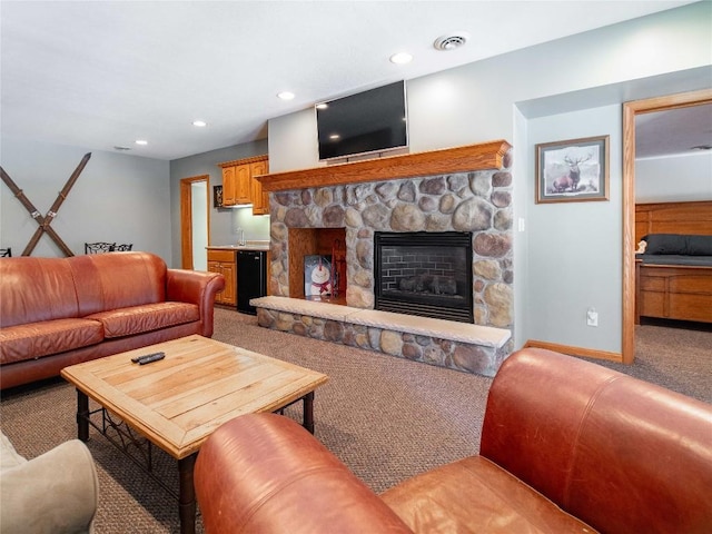 living room with light carpet, visible vents, baseboards, recessed lighting, and a stone fireplace
