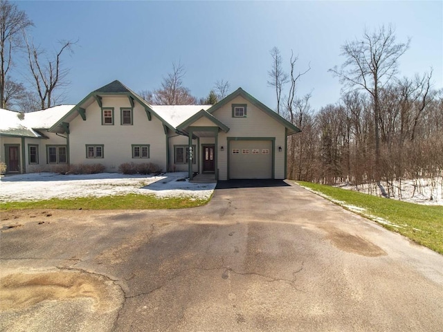 traditional-style home with a garage and aphalt driveway