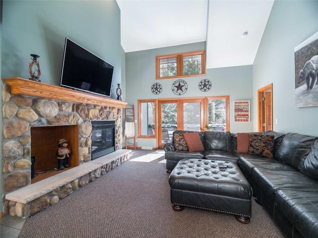 carpeted living area featuring a stone fireplace and high vaulted ceiling