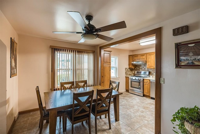 tiled dining space featuring ceiling fan and a wealth of natural light