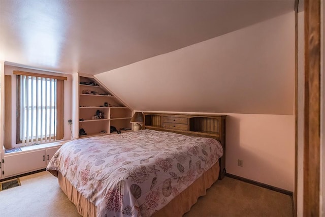 carpeted bedroom with lofted ceiling