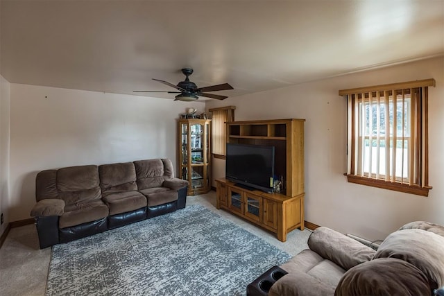 carpeted living room with ceiling fan