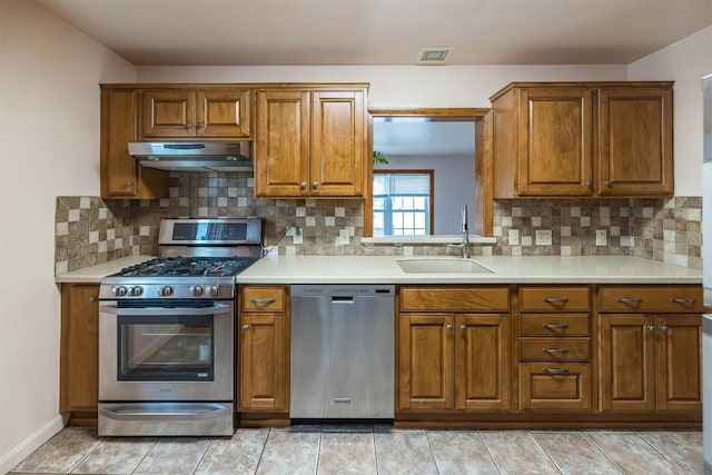 kitchen featuring light tile patterned flooring, sink, appliances with stainless steel finishes, and tasteful backsplash