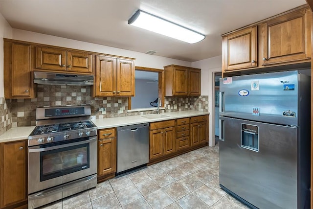 kitchen with decorative backsplash, light tile patterned floors, sink, and appliances with stainless steel finishes