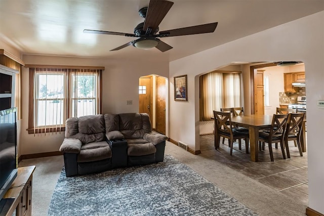 living room with ceiling fan and dark colored carpet