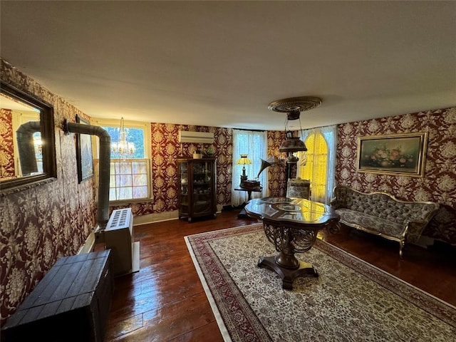 sitting room with dark hardwood / wood-style floors, a chandelier, and a wall unit AC