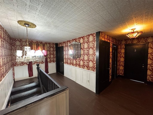 corridor with dark hardwood / wood-style flooring and a chandelier