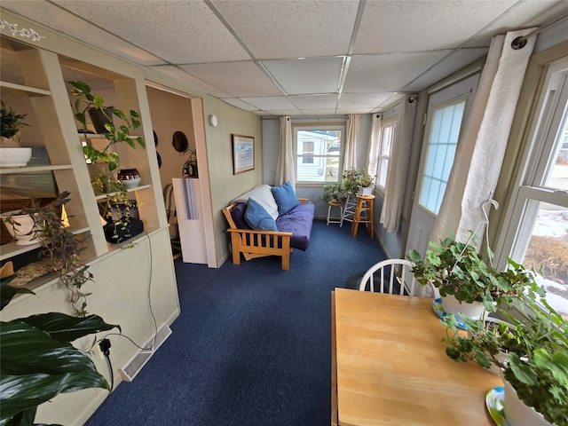 sitting room with a drop ceiling and carpet