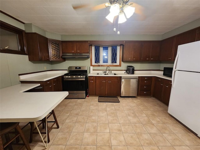 kitchen featuring a breakfast bar, sink, ceiling fan, kitchen peninsula, and stainless steel appliances