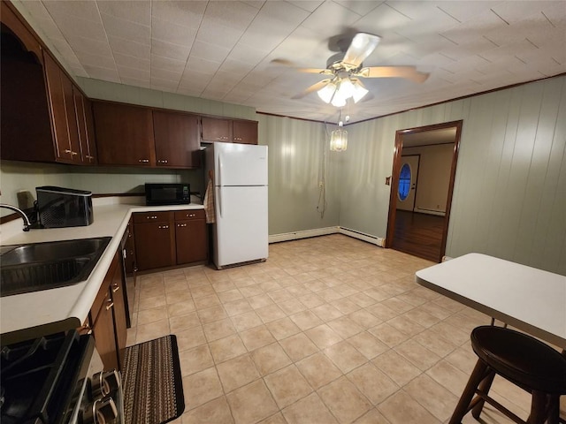 kitchen featuring ceiling fan, white refrigerator, dark brown cabinets, and sink