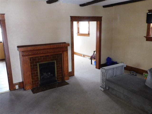 unfurnished living room featuring a brick fireplace, carpet flooring, and beam ceiling