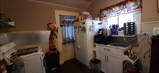 kitchen with vaulted ceiling, white cabinets, and white appliances