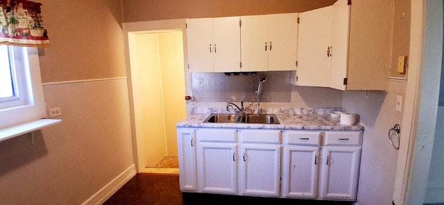 2677 Cherry St, Erie, PA 16508 - kitchen featuring light countertops, baseboards, a sink, and white cabinetry