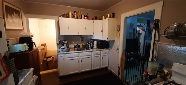 kitchen with white cabinetry, sink, and electric range