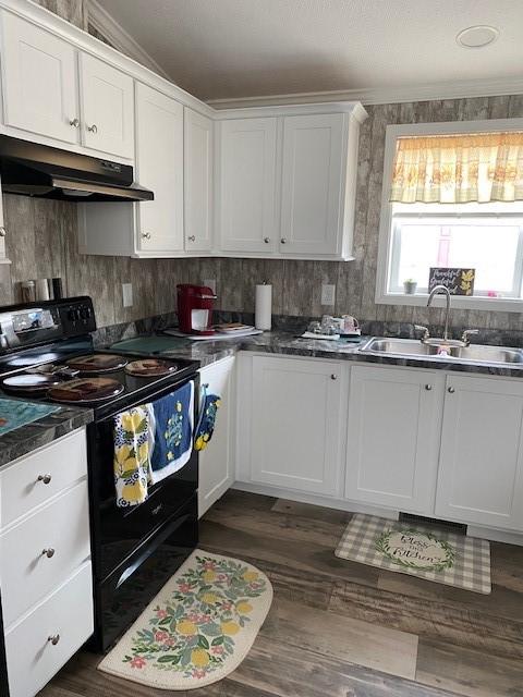 kitchen featuring dark countertops, under cabinet range hood, black electric range, white cabinetry, and a sink