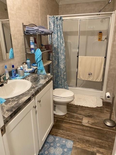 full bath with vanity, wood finished floors, a shower stall, and toilet