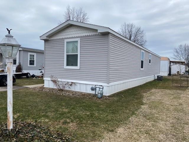 view of side of property featuring a yard and central AC unit