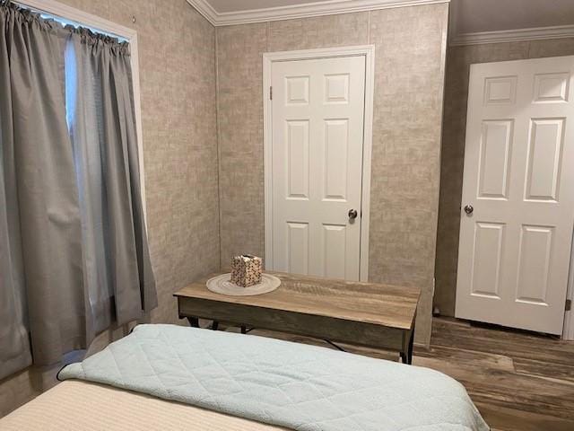 bedroom with crown molding and wood finished floors