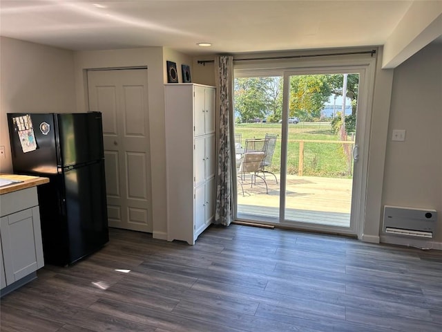 kitchen featuring black refrigerator, white cabinets, and dark hardwood / wood-style floors