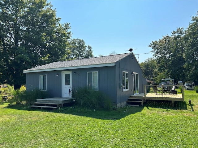 view of front of home with a deck and a front lawn