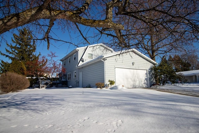 snow covered property featuring a garage