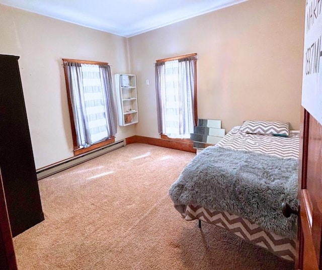 bedroom featuring multiple windows, baseboard heating, and carpet flooring