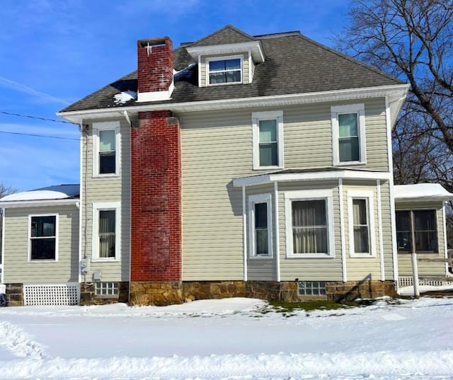 traditional style home featuring a shingled roof and a chimney