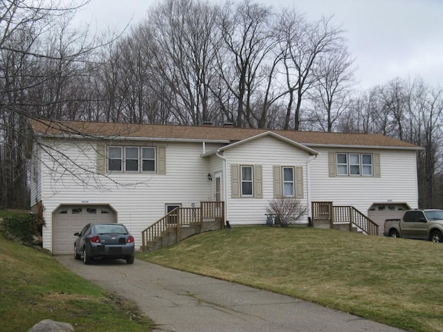 split foyer home featuring a garage and a front yard