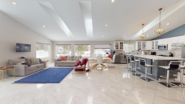 living room featuring a notable chandelier and high vaulted ceiling