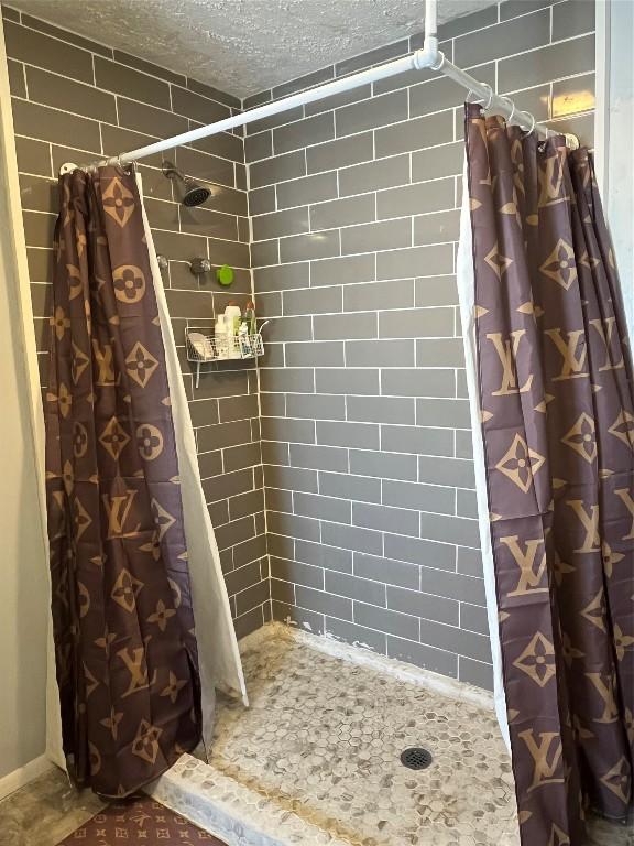 bathroom featuring a textured ceiling and a shower with curtain