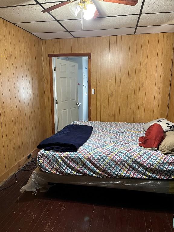 bedroom featuring wood-type flooring and wood walls