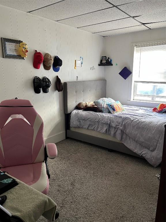 carpeted bedroom with a paneled ceiling