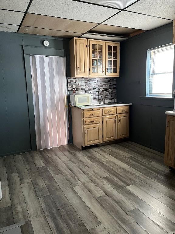 kitchen with hardwood / wood-style flooring, tasteful backsplash, sink, and a drop ceiling