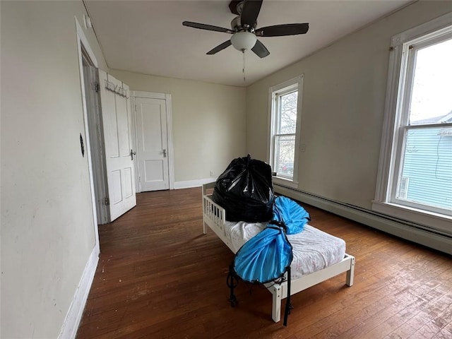 living area with baseboards, a baseboard radiator, ceiling fan, and wood finished floors