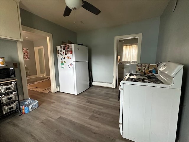 kitchen with wood finished floors, white appliances, washer / clothes dryer, a baseboard heating unit, and a ceiling fan