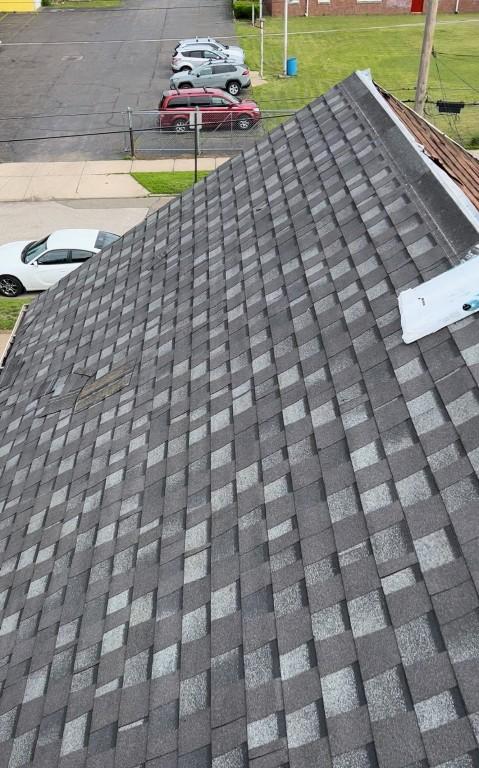 exterior details featuring roof with shingles
