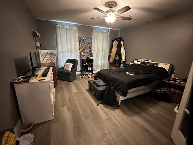 bedroom with a ceiling fan and light wood-style floors