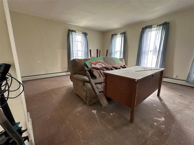 bedroom with wood finished floors and a baseboard heating unit